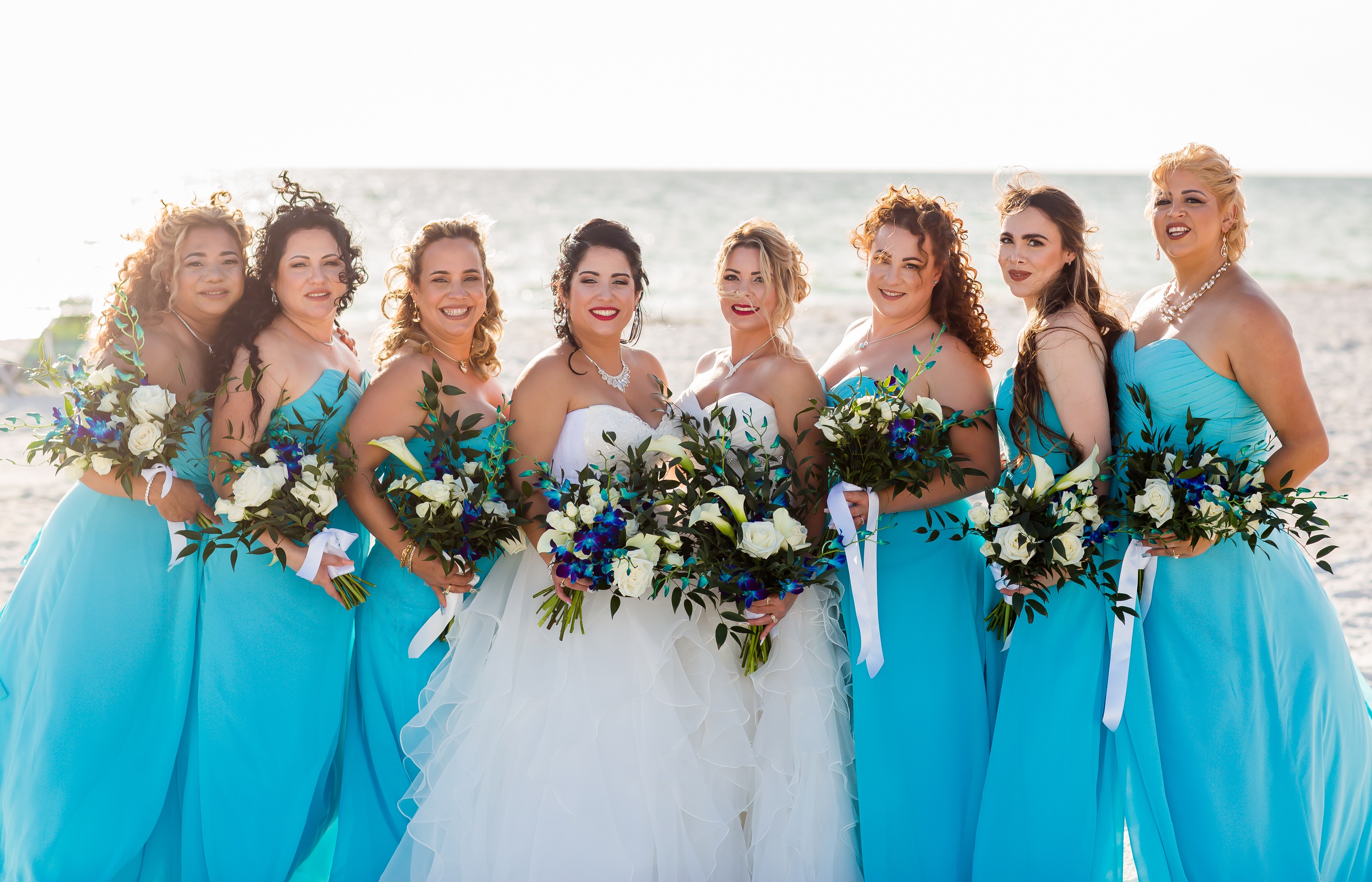brides with their bridemaids in bright blue dresses