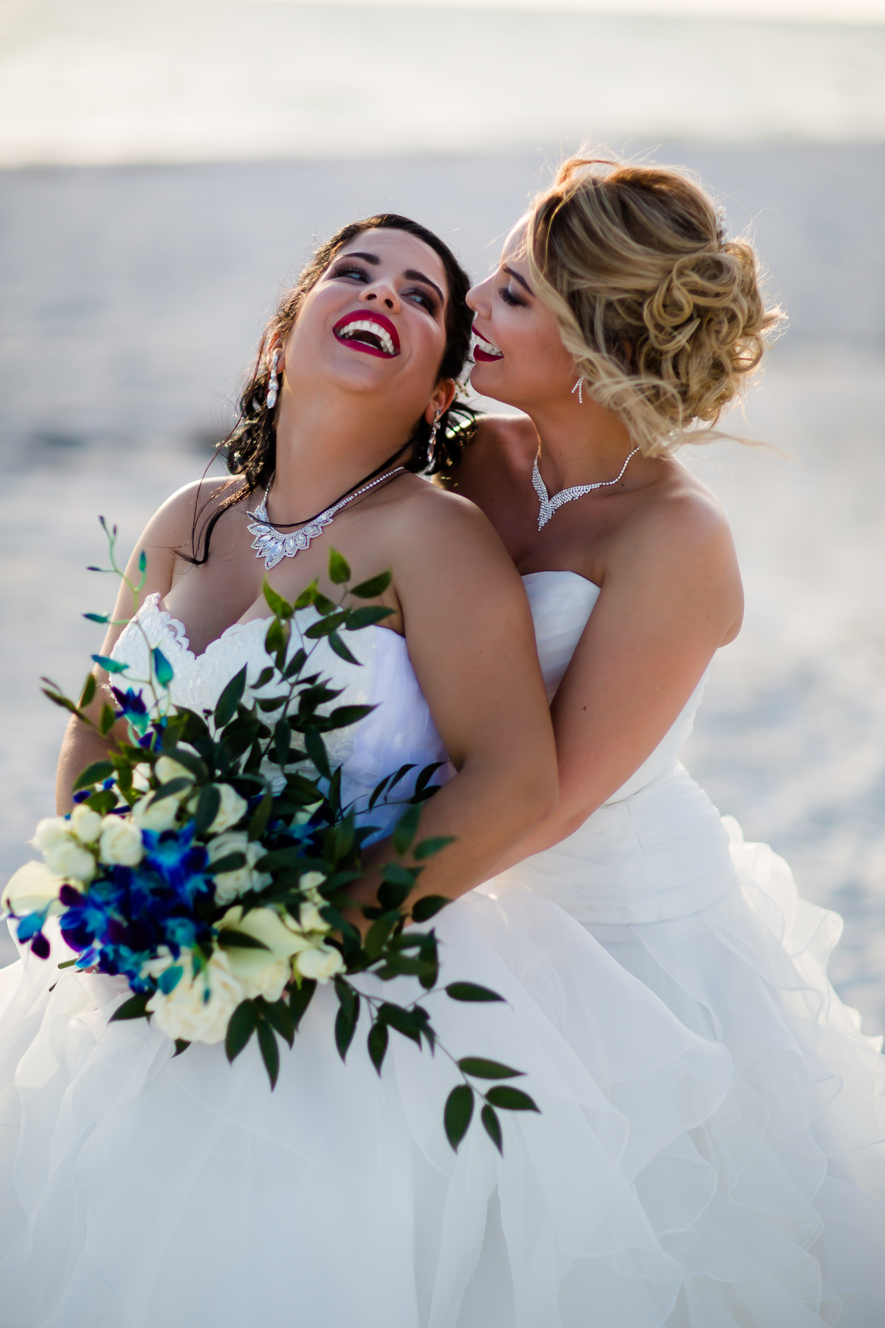 brides in lace tulle wedding gowns with white and blue bouquets