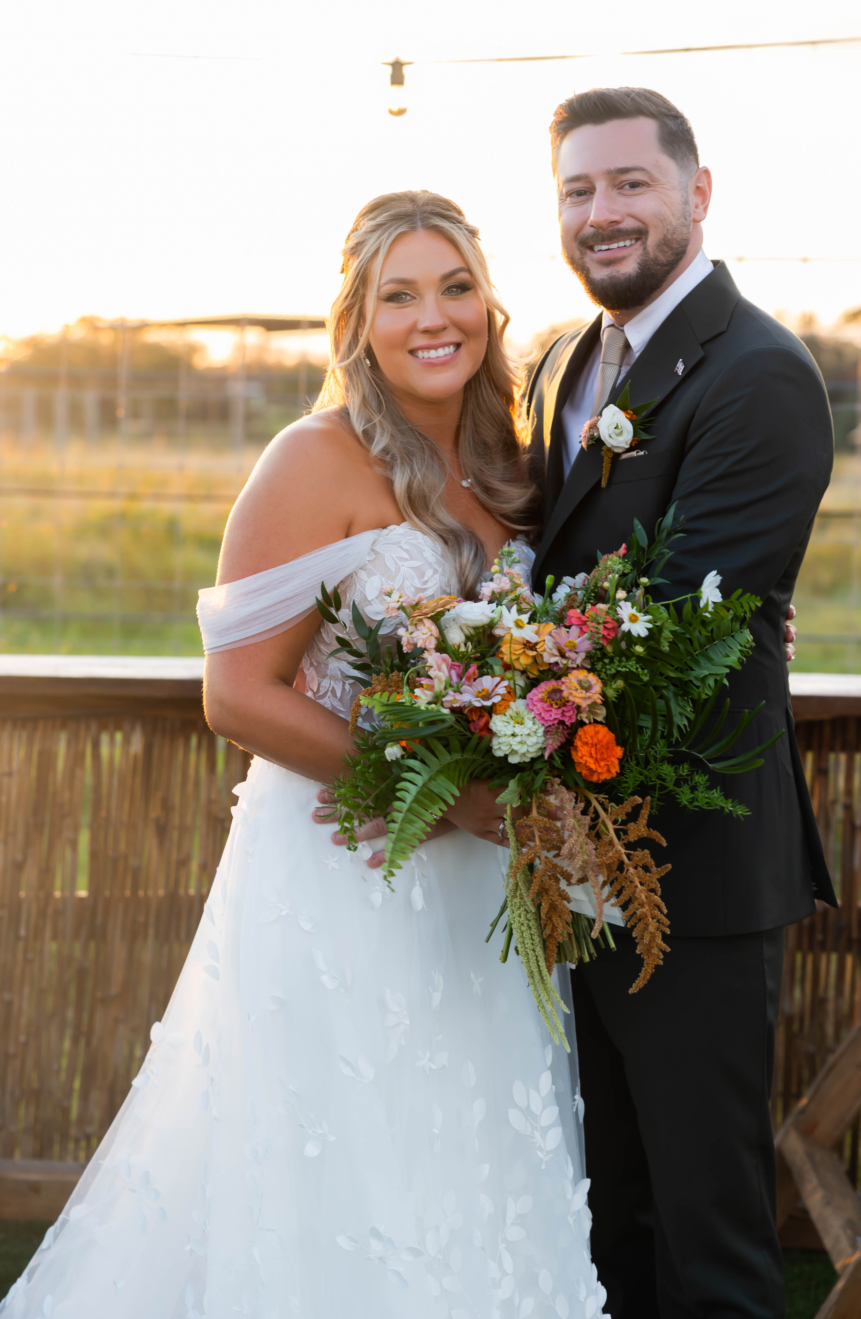bride in off shoulder gown and groom in black suit