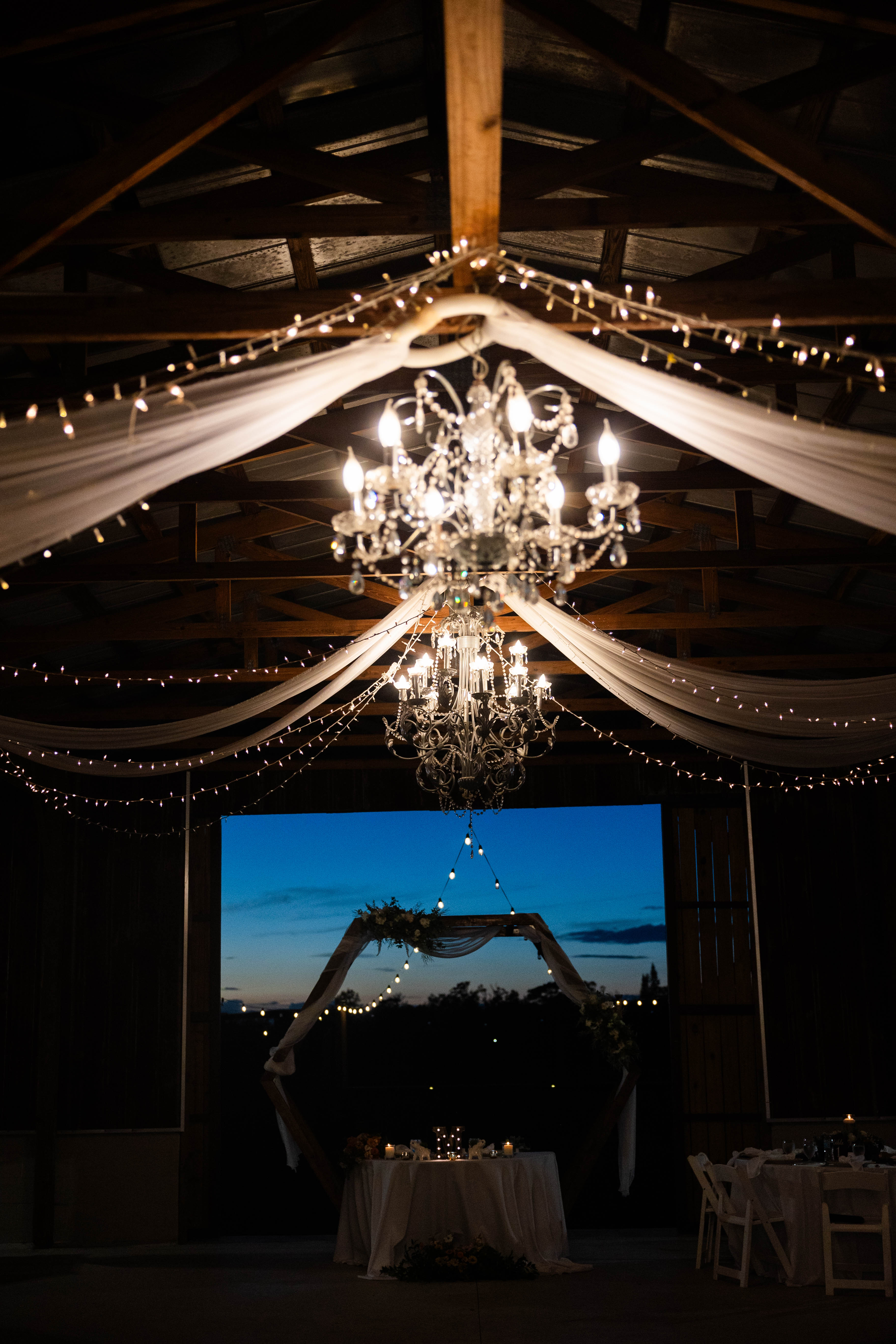 string lights and chandelier for barn wedding