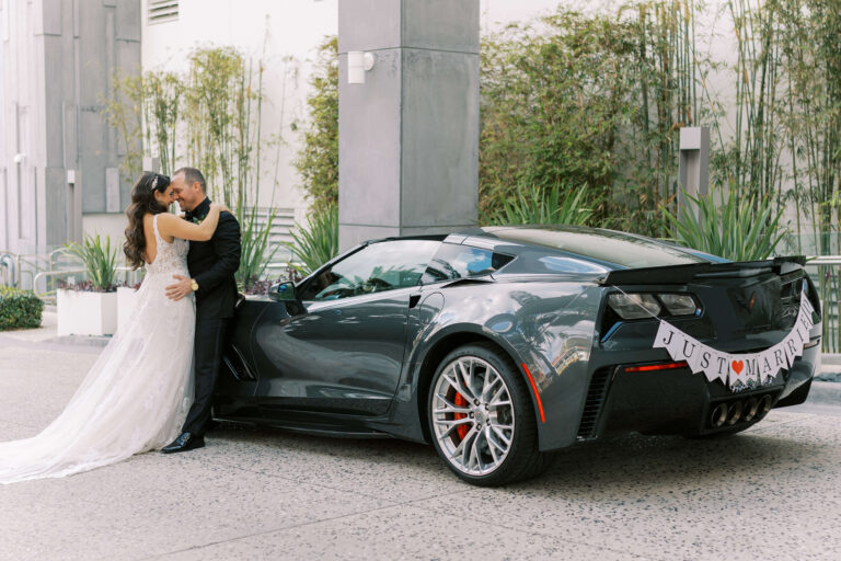 bride and groom with classic car outside Opal Sands