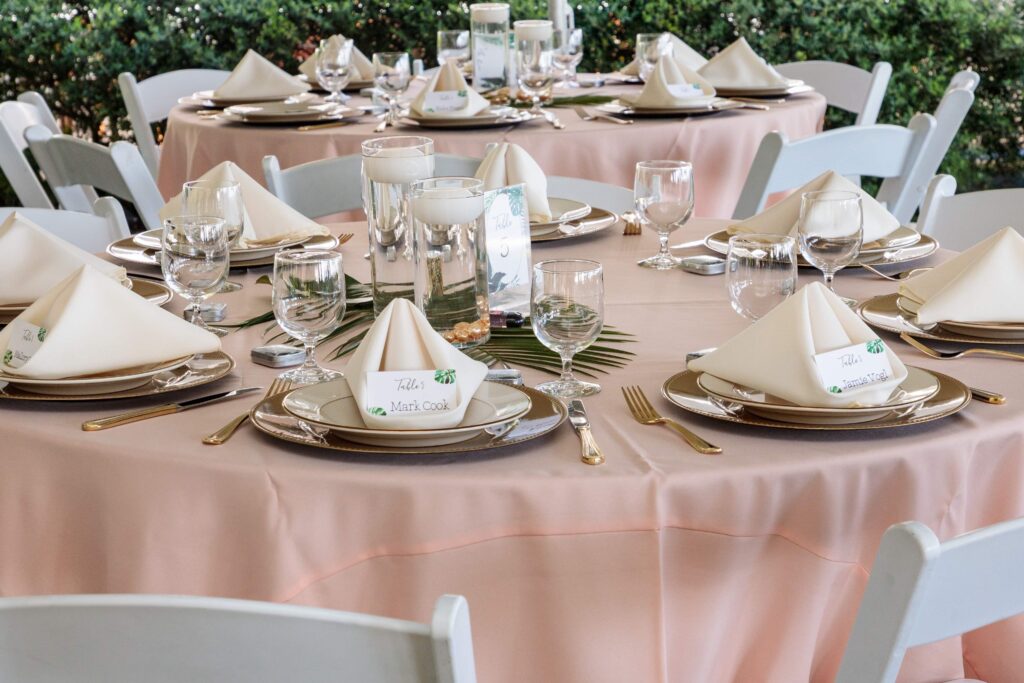 wedding tablescape with palm leaves, floating candles, and peach linens