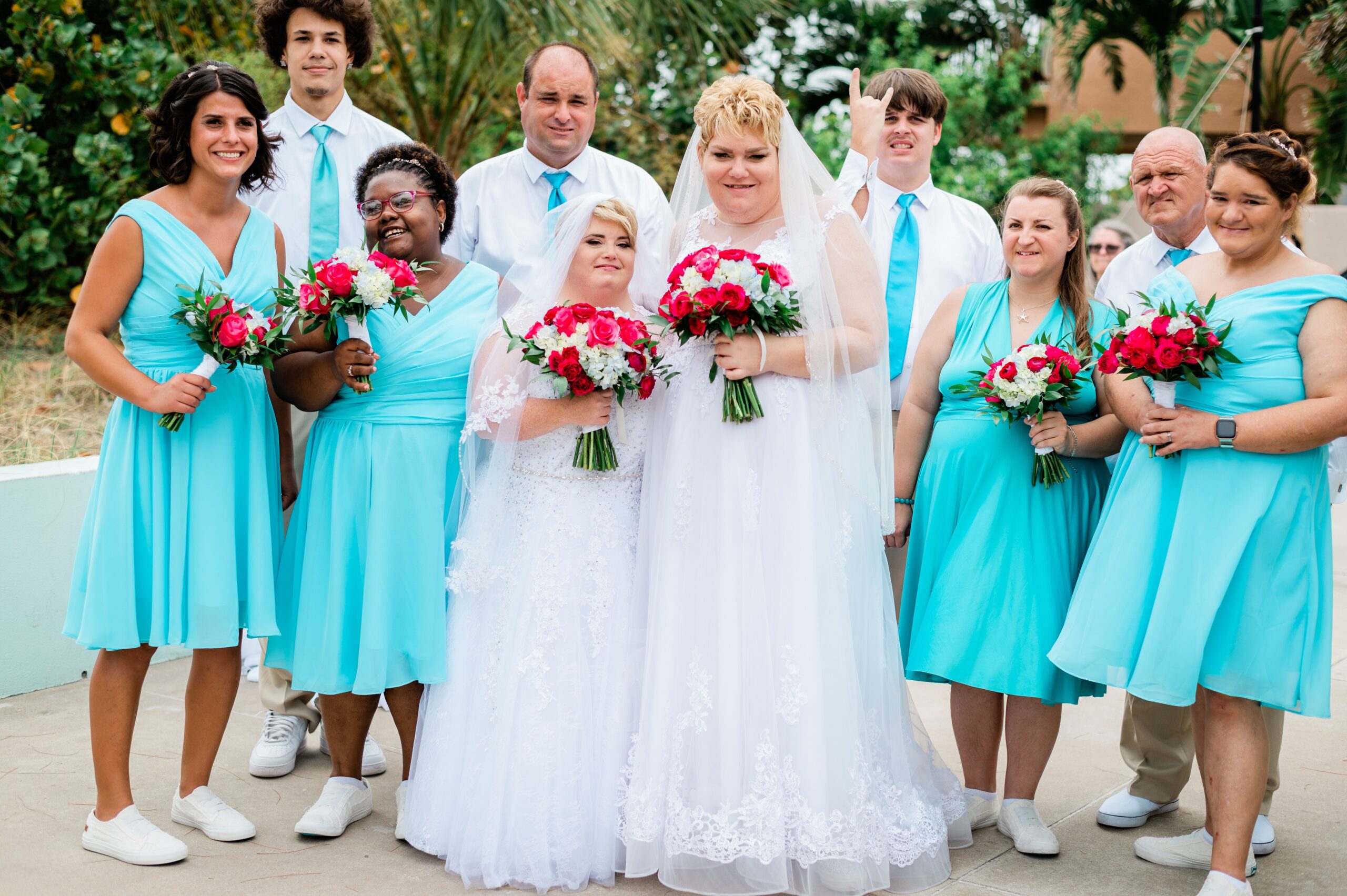 wedding party in white and blue with white and red bouquets