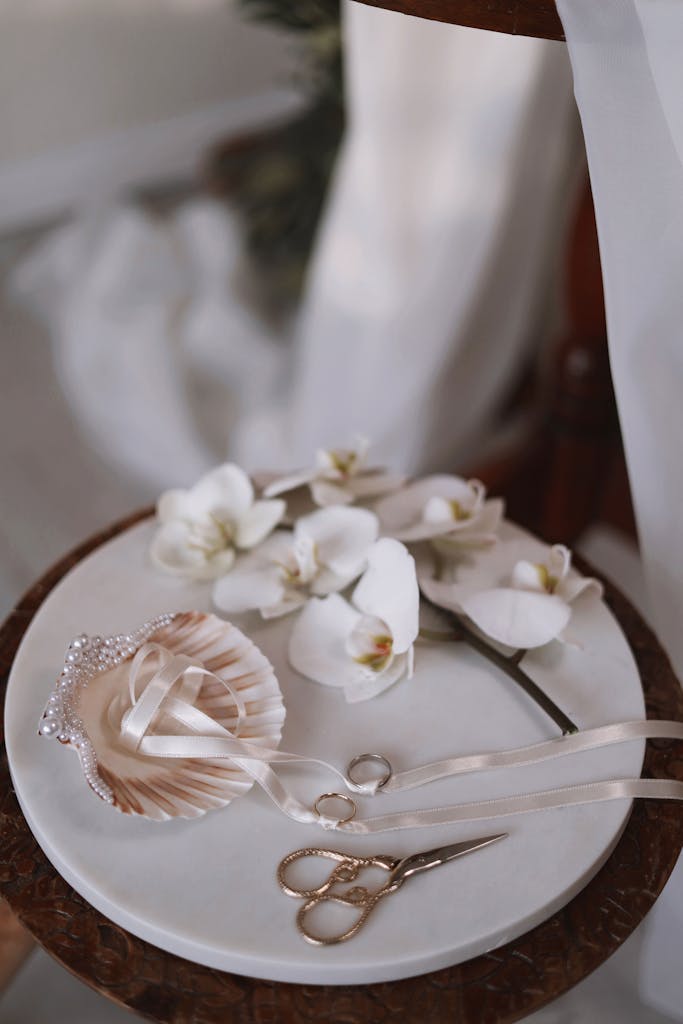 Close-up of wedding accessories with orchids and elegant decor on a plate.